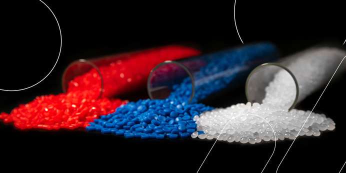 Red, blue, and white plastic pellets pouring out of glass vials