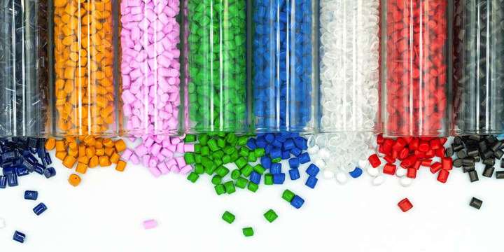Colored plastic pellets spilling out of glass beakers