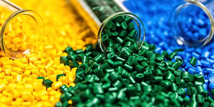 yellow, green, and blue recycled pellets spilt out of a vial